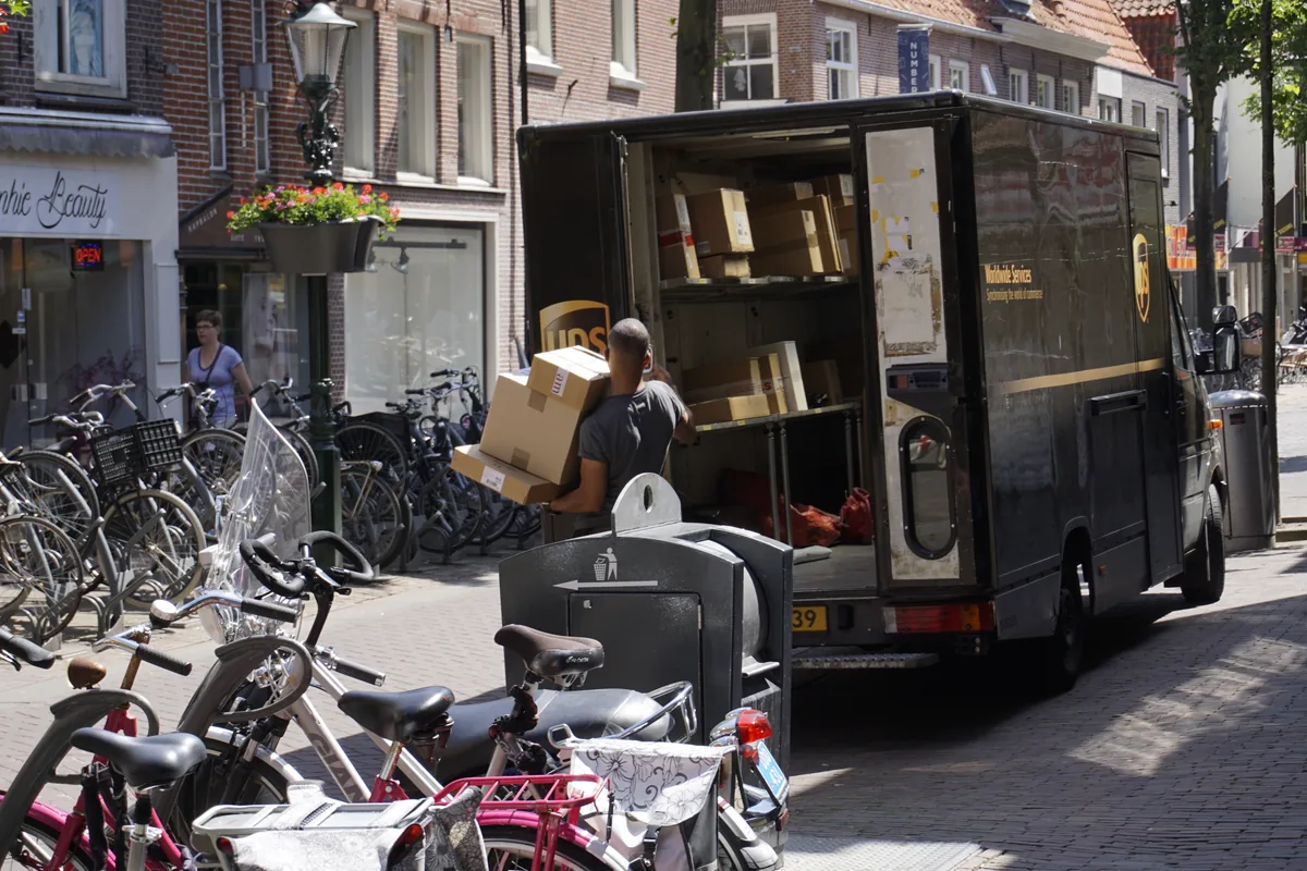 Commercial courier delivery van operating on a residential street for scheduled parcel collections