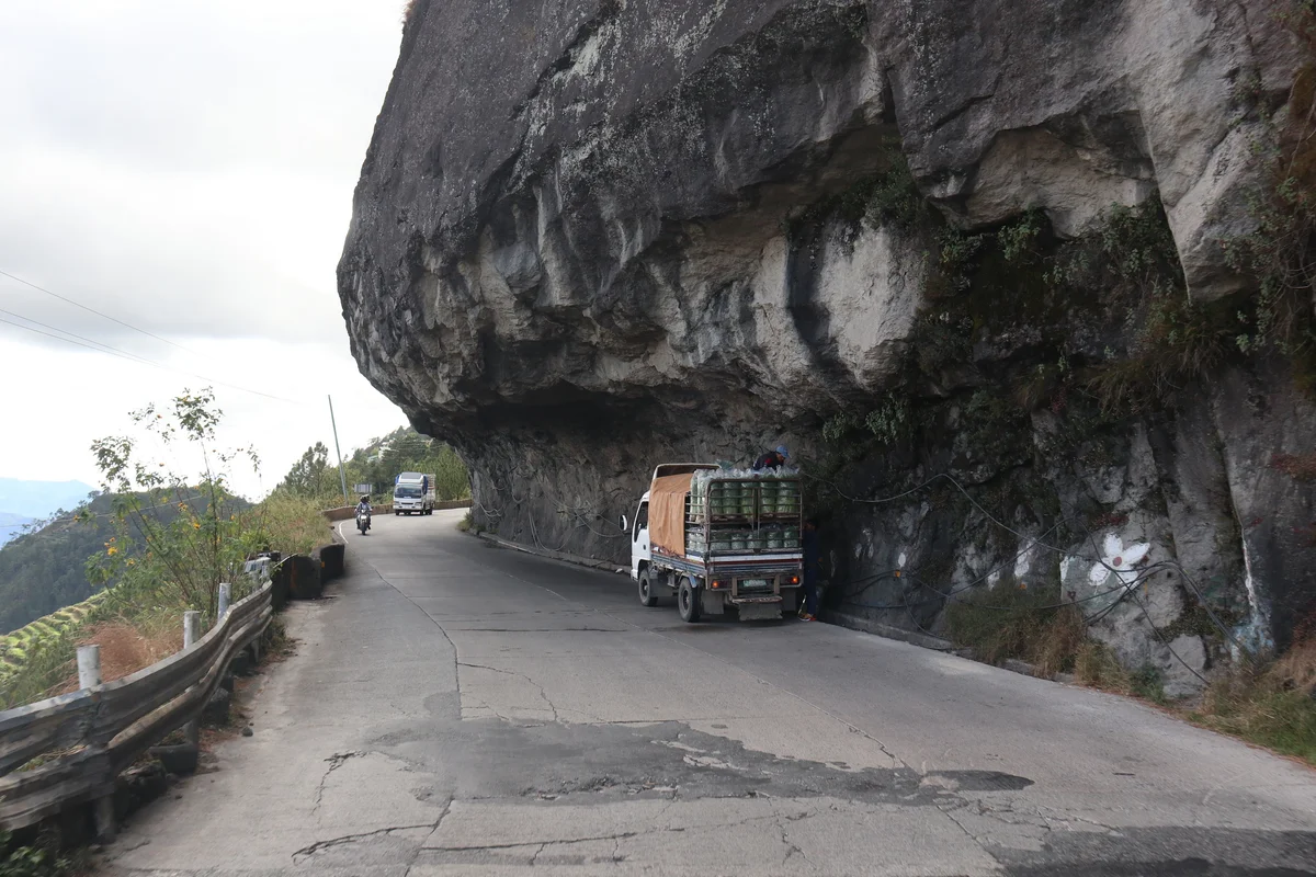 Cargo truck navigating the rocky mountain pass of Halsema Highway in Benguet, illustrating overland freight transit to remote provincial highland zones.