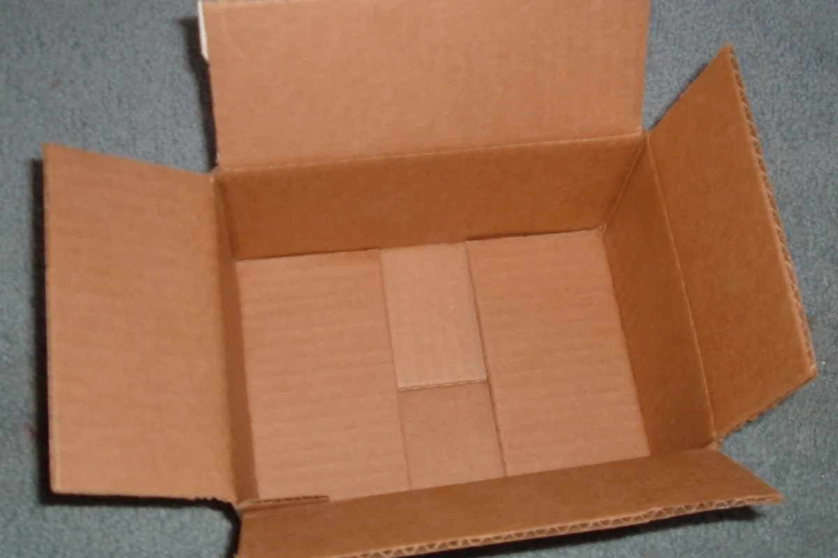 Sealed corrugated cardboard parcel box showing reinforced packaging tape along the outer seams