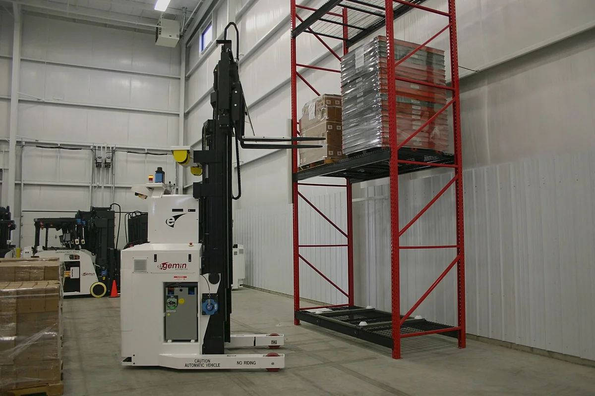 Industrial forklift maneuvering heavy palletized cargo inside a commercial freight distribution center.