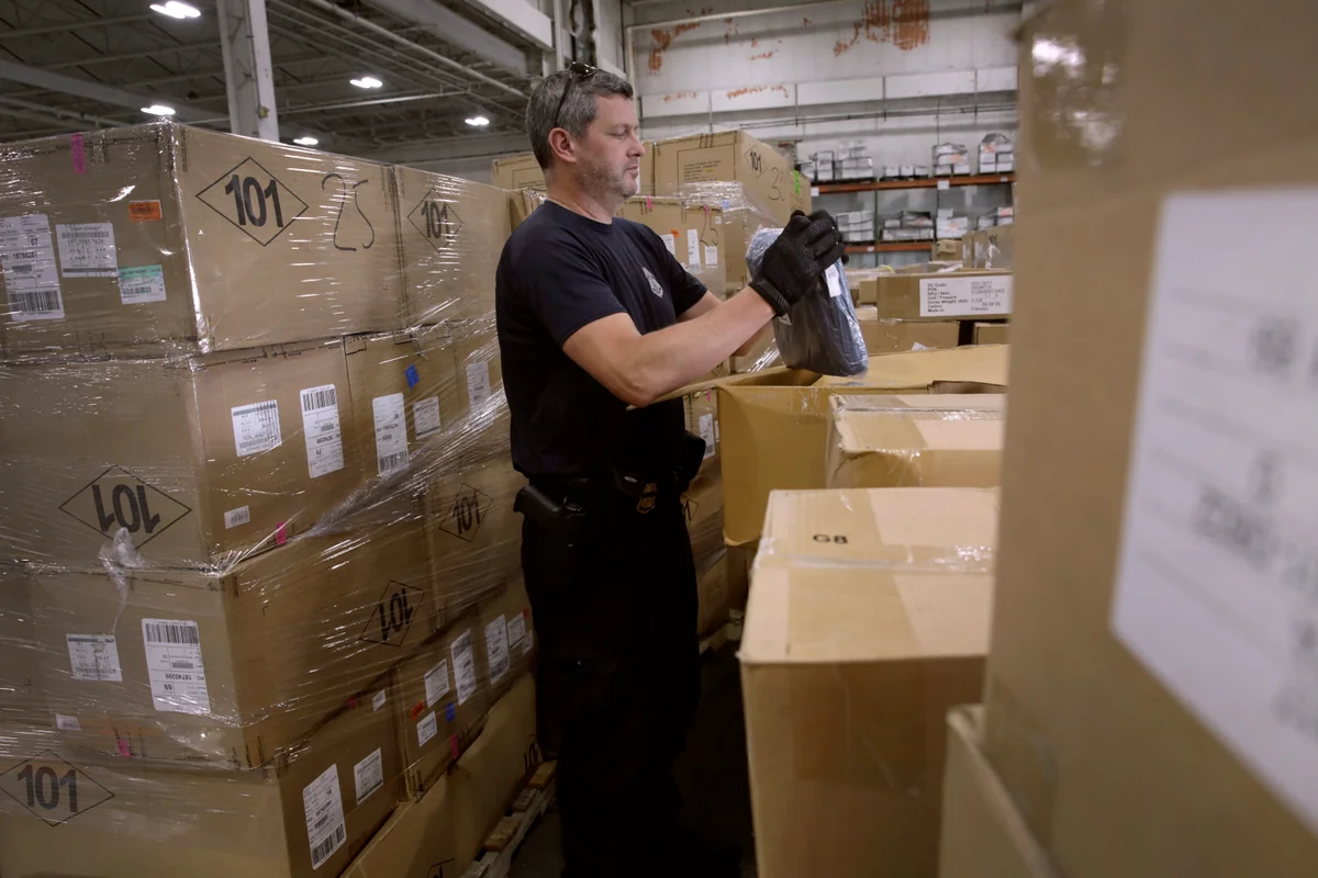 Logistics personnel organizing and staging heavy cargo boxes in a central fulfillment distribution center