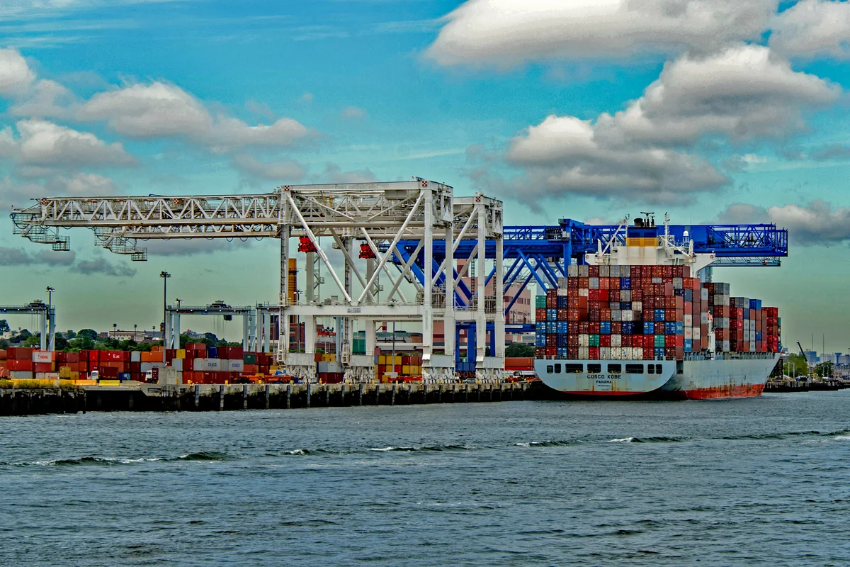 Container freight vessel loading cargo containers at inter-island shipping seaport terminal