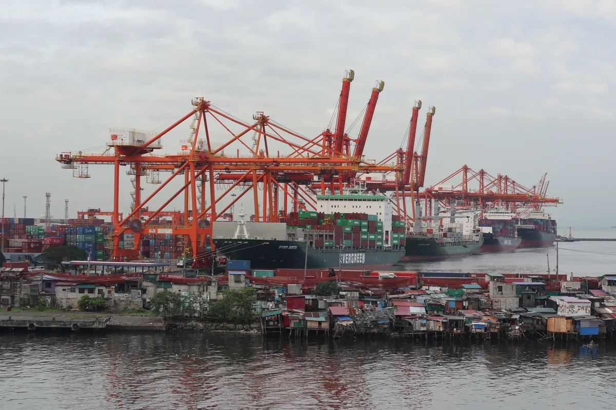 Gantry cranes and shipping container stacks at the Manila International Container Terminal along the Port of Manila
