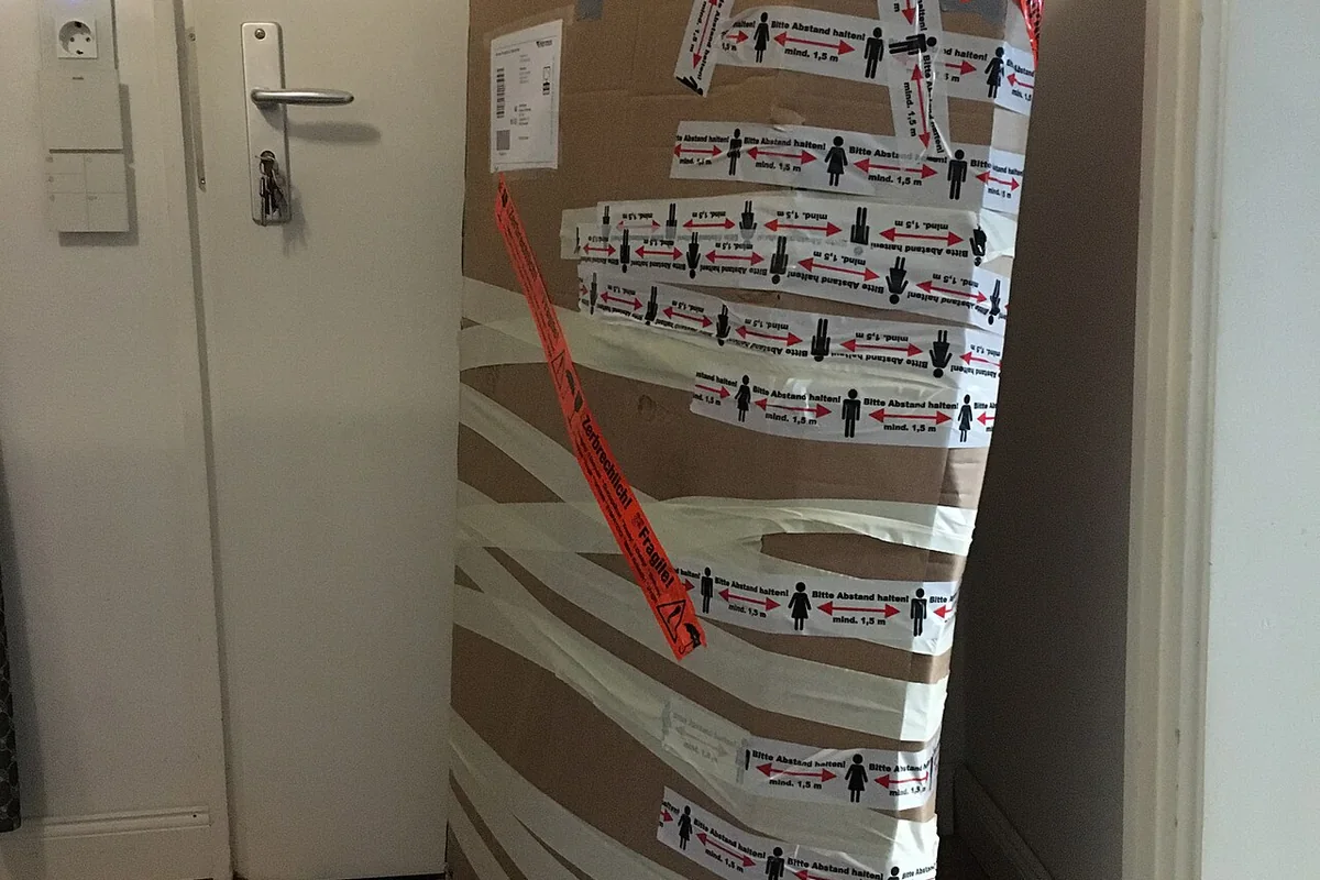 Reinforced cardboard shipping carton prepared for courier dispatch with exterior dimensional measurements.