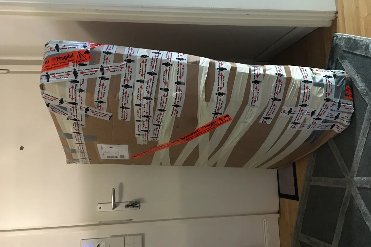 Heavy-duty corrugated cardboard shipping box sealed with wide adhesive packaging tape across all flaps