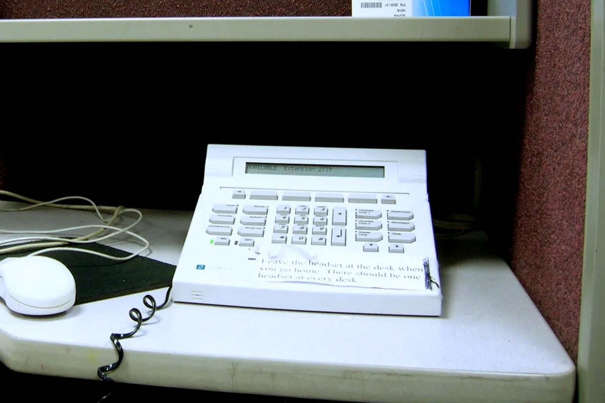 Commercial call center telephone console and headset station used by hotline support agents