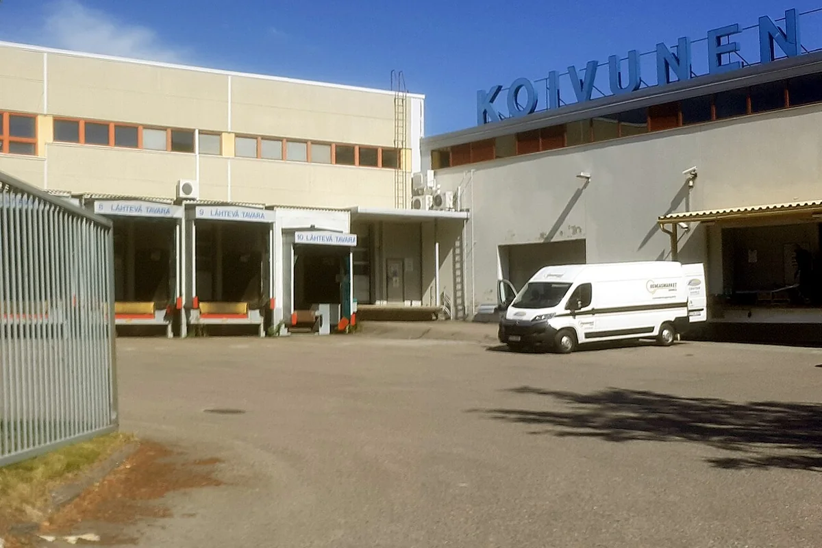 Logistics warehouse loading bays where consolidation vans dock to transfer afternoon branch shipments.